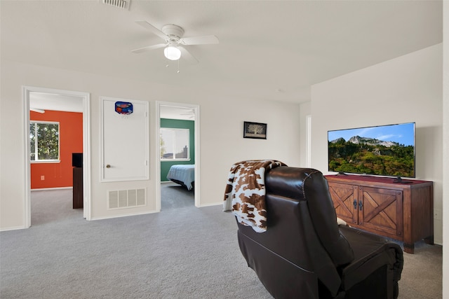 carpeted living room featuring ceiling fan