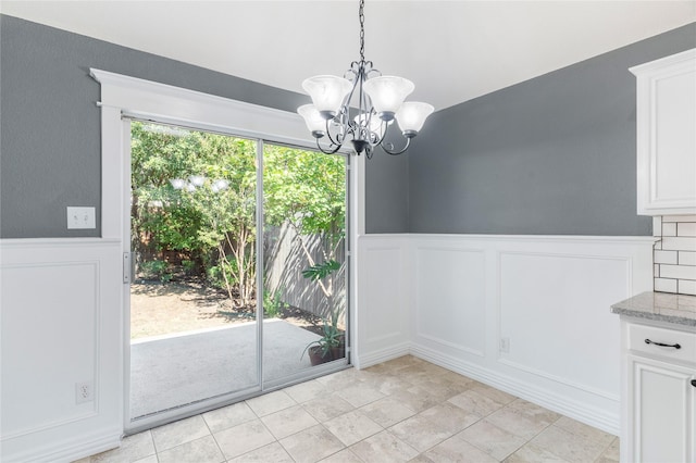 unfurnished dining area with a chandelier and light tile patterned floors