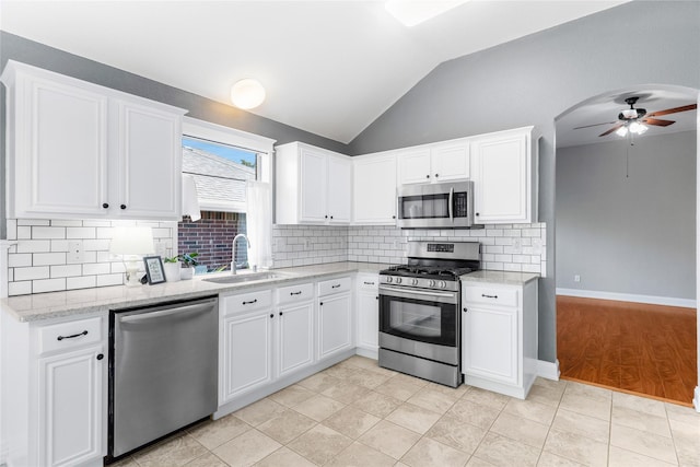 kitchen with sink, vaulted ceiling, white cabinetry, and appliances with stainless steel finishes