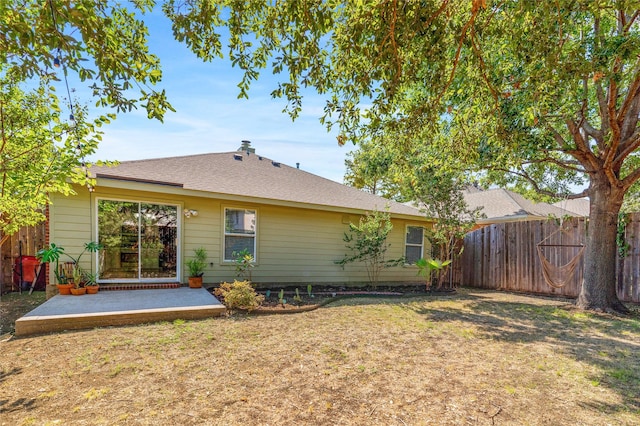 rear view of house featuring a patio and a lawn