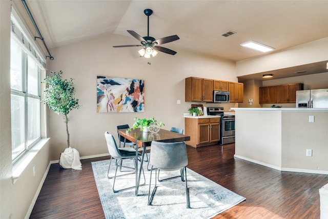 dining room with dark wood-type flooring, a healthy amount of sunlight, and lofted ceiling