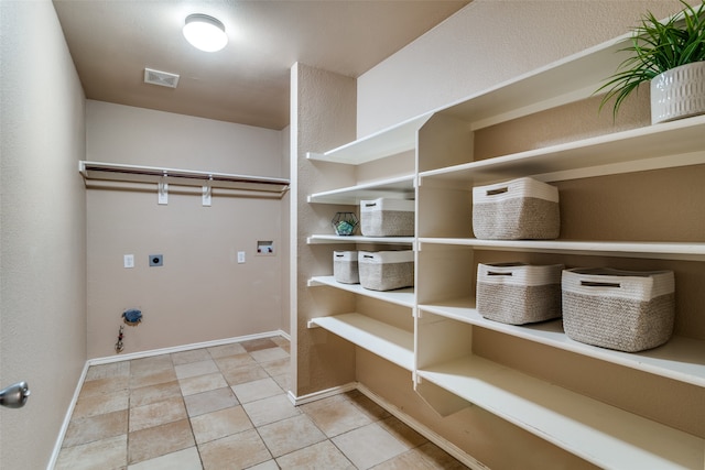 laundry area with hookup for a gas dryer, hookup for an electric dryer, washer hookup, and tile patterned floors