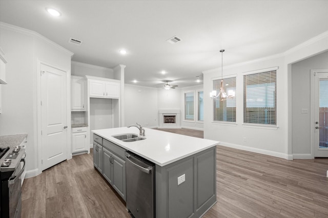 kitchen featuring appliances with stainless steel finishes, sink, gray cabinets, white cabinetry, and an island with sink