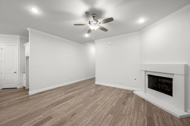 unfurnished living room featuring ceiling fan, light wood-type flooring, and ornamental molding