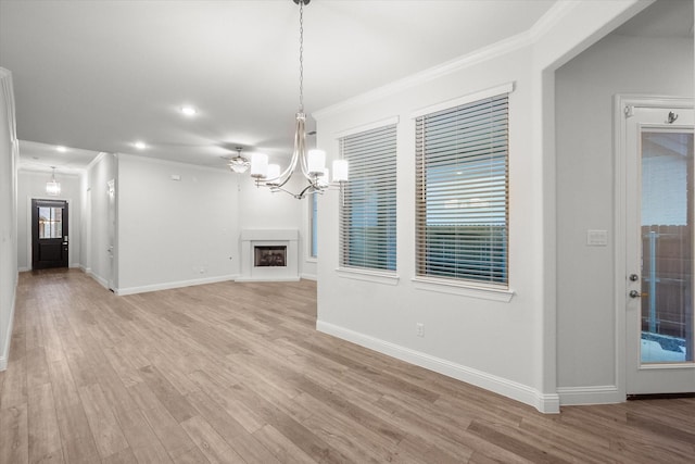 unfurnished living room with a chandelier, light hardwood / wood-style floors, and ornamental molding