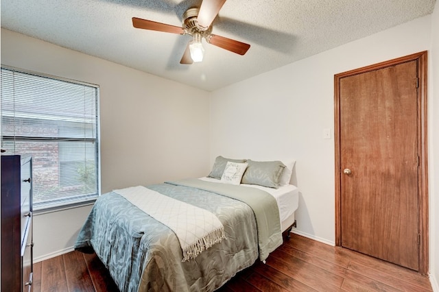 bedroom with multiple windows, ceiling fan, hardwood / wood-style floors, and a textured ceiling