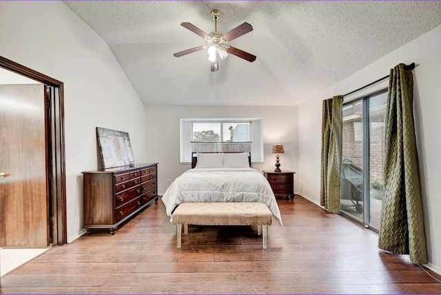 bedroom featuring ceiling fan, light hardwood / wood-style floors, lofted ceiling, and access to outside