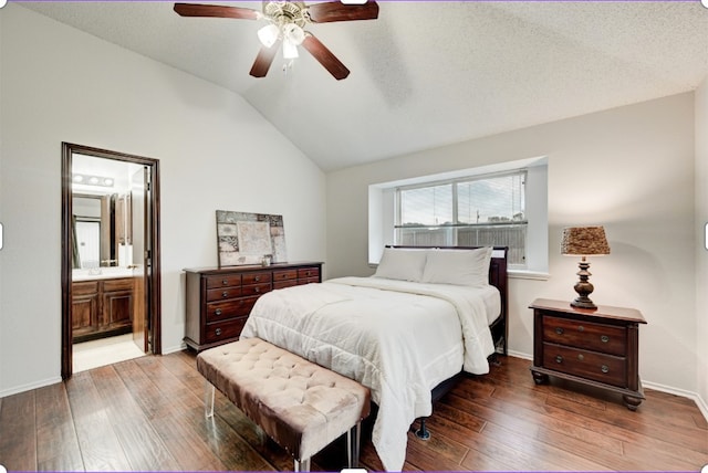 bedroom featuring ceiling fan, ensuite bathroom, a textured ceiling, lofted ceiling, and hardwood / wood-style flooring