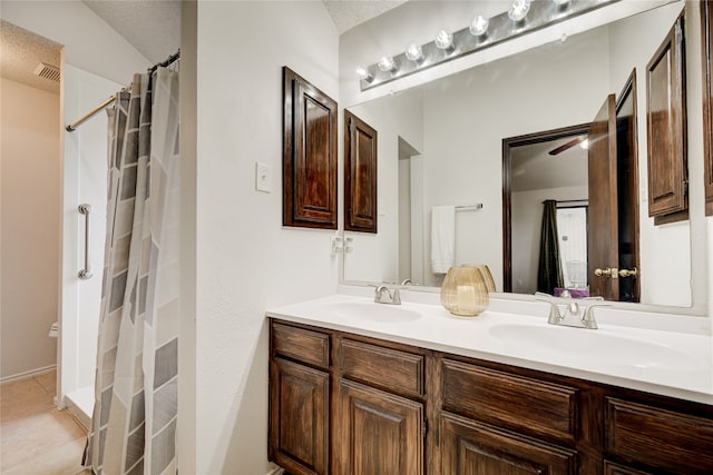 bathroom featuring vanity, tile patterned flooring, ceiling fan, a textured ceiling, and curtained shower