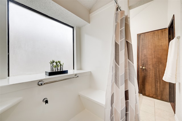 bathroom with a shower with curtain and tile patterned flooring