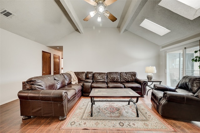 living room with lofted ceiling with skylight, ceiling fan, and wood-type flooring