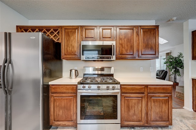 kitchen with appliances with stainless steel finishes and a textured ceiling