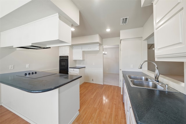 kitchen featuring oven, sink, cooktop, white cabinets, and light hardwood / wood-style floors