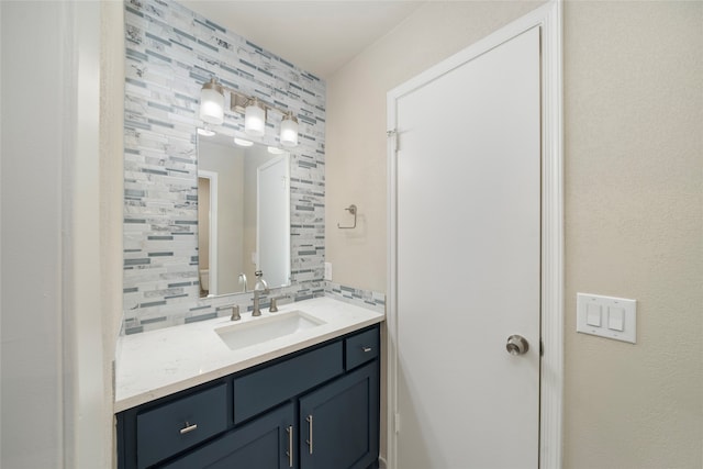 bathroom featuring vanity and backsplash