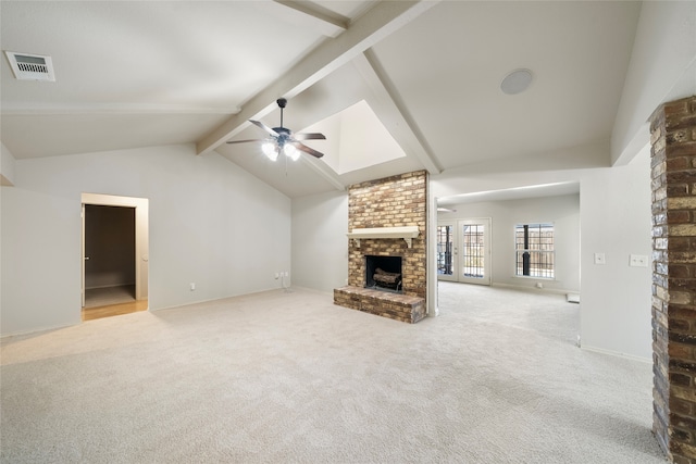 unfurnished living room featuring beam ceiling, light colored carpet, a fireplace, and ceiling fan