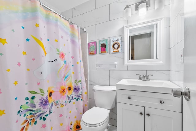 bathroom featuring vanity, toilet, tile walls, and walk in shower