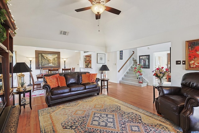 living room featuring lofted ceiling, hardwood / wood-style flooring, and ceiling fan