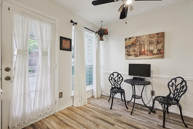 interior space featuring light wood-type flooring, a textured ceiling, and ceiling fan