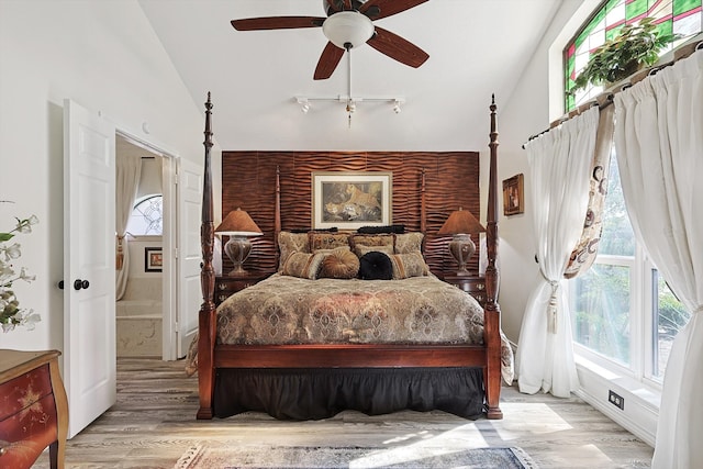 bedroom featuring ceiling fan, light hardwood / wood-style flooring, and high vaulted ceiling