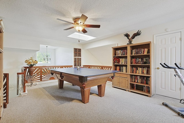 rec room featuring ceiling fan with notable chandelier, a textured ceiling, light carpet, and a skylight