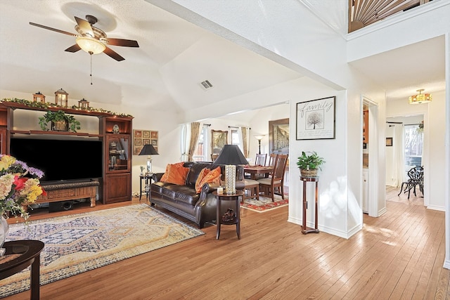 living room with high vaulted ceiling, ceiling fan, and light hardwood / wood-style floors