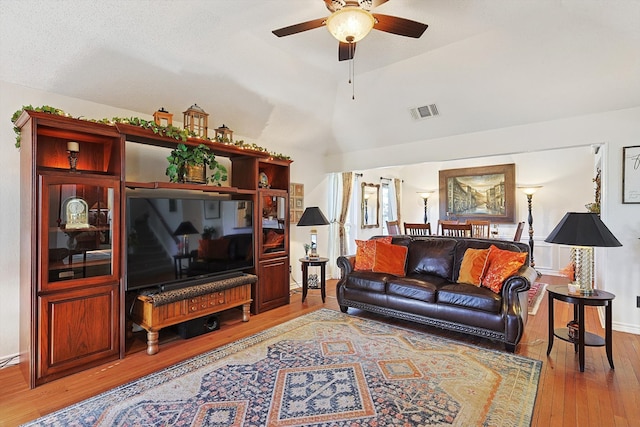 living room with lofted ceiling, wood-type flooring, and ceiling fan