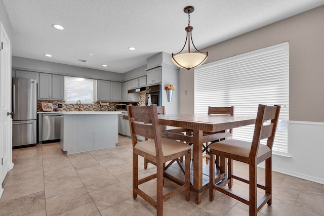 dining room featuring sink and a textured ceiling