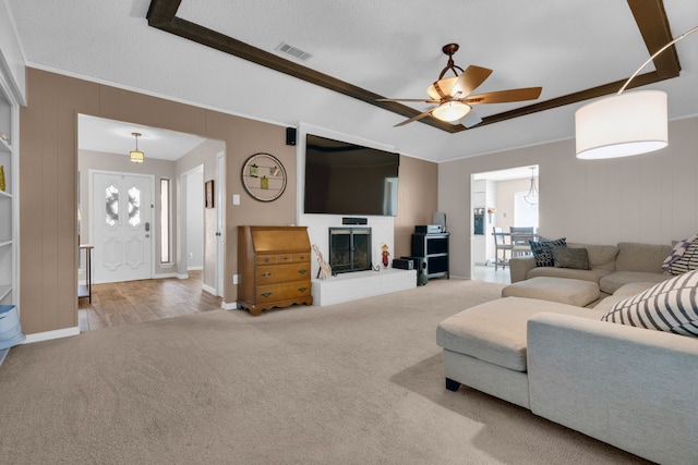 living room with carpet, crown molding, a textured ceiling, and ceiling fan