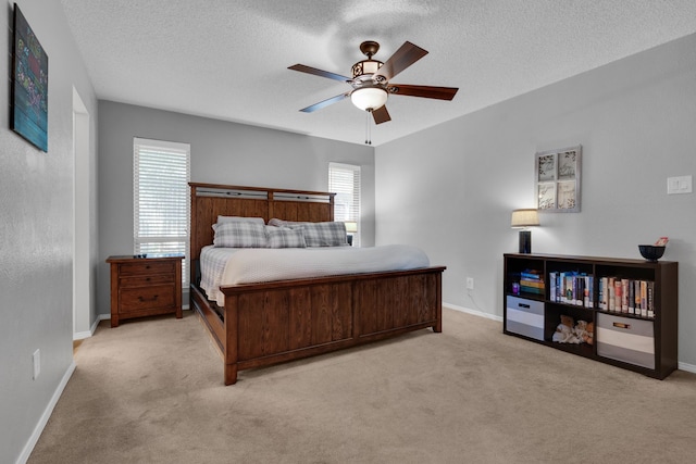 bedroom featuring light carpet, a textured ceiling, and ceiling fan