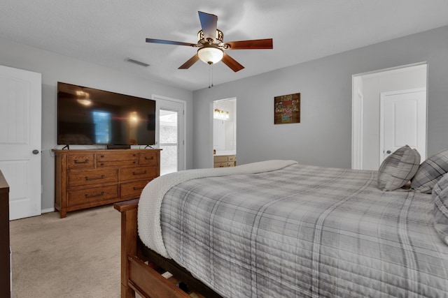 bedroom with connected bathroom, light carpet, a textured ceiling, and ceiling fan