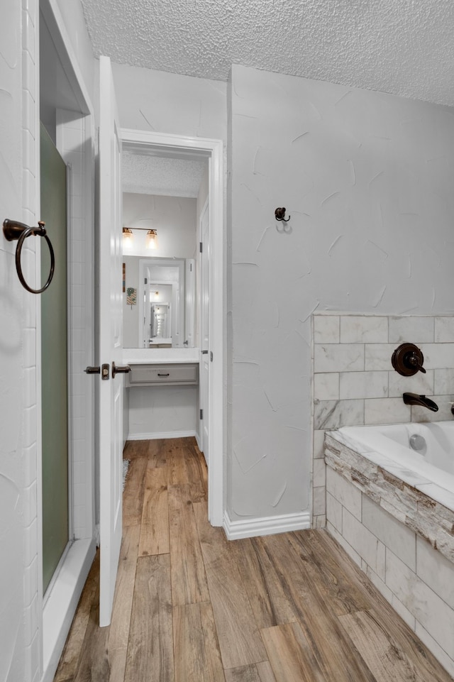 bathroom with vanity, hardwood / wood-style floors, a textured ceiling, and separate shower and tub