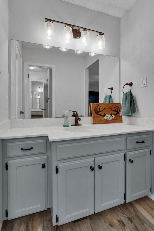 bathroom with vanity, a textured ceiling, and hardwood / wood-style flooring