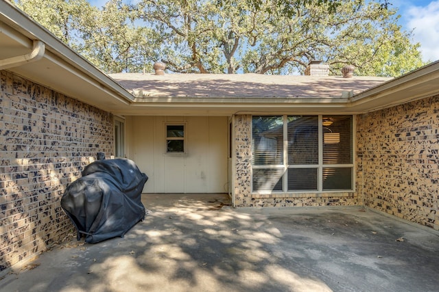 view of exterior entry with a patio area