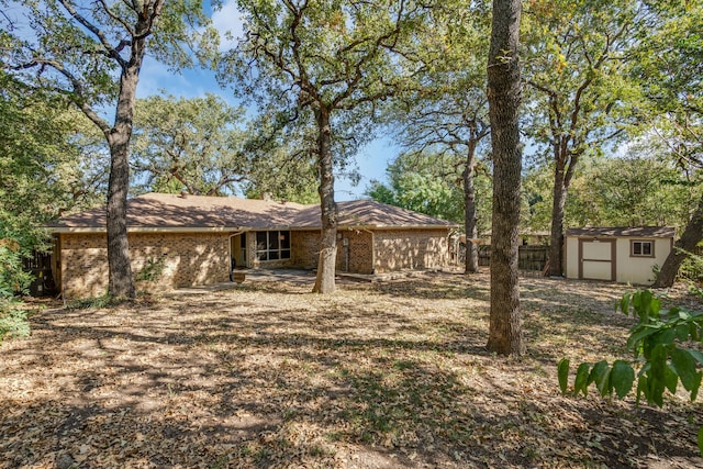 rear view of property featuring a storage shed