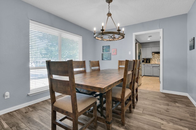 dining space featuring light hardwood / wood-style floors, a wealth of natural light, and a chandelier