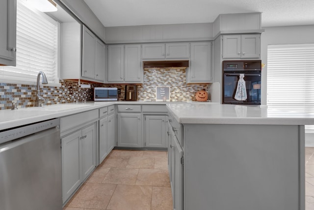 kitchen featuring gray cabinetry, appliances with stainless steel finishes, sink, backsplash, and light tile patterned floors