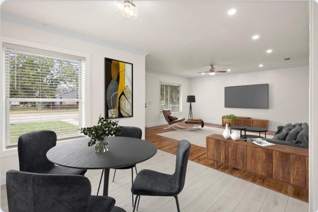 dining space with ornamental molding, light wood-type flooring, plenty of natural light, and ceiling fan