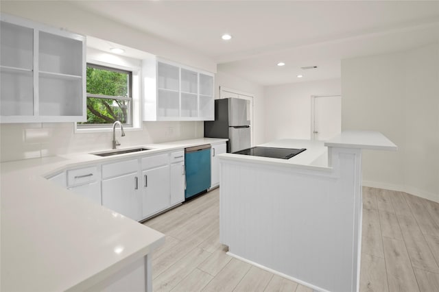 kitchen with sink, light wood-type flooring, white cabinetry, and appliances with stainless steel finishes