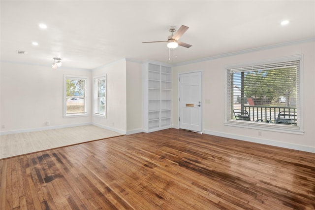 spare room with ceiling fan, plenty of natural light, hardwood / wood-style floors, and crown molding