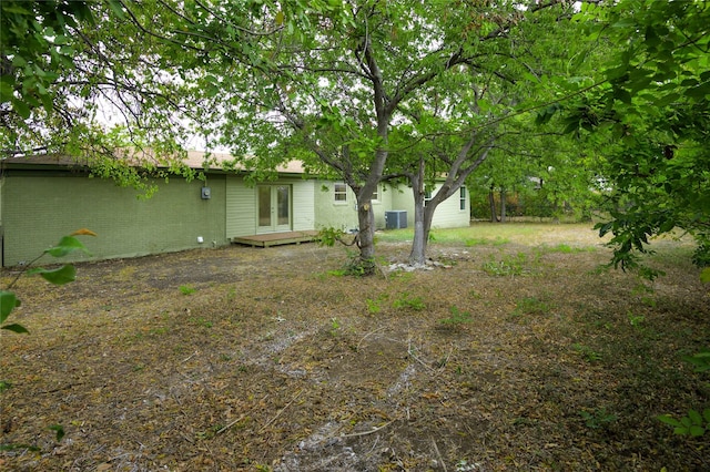 view of yard featuring central AC unit and french doors