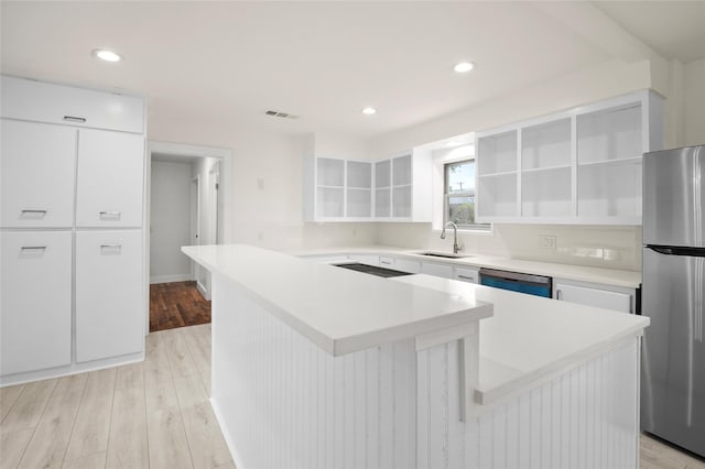 kitchen with sink, white cabinets, a center island, and appliances with stainless steel finishes