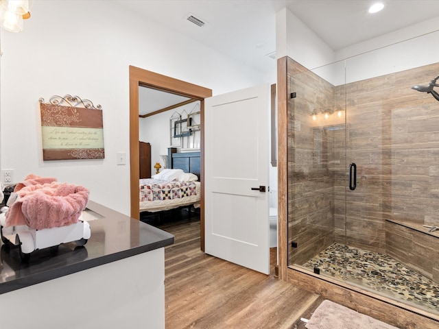 bathroom featuring hardwood / wood-style floors and a shower with shower door