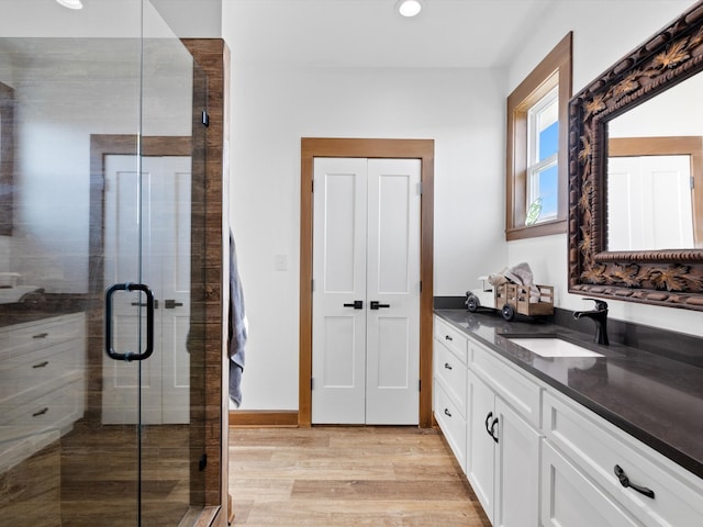 bathroom featuring vanity, hardwood / wood-style floors, and a shower with door