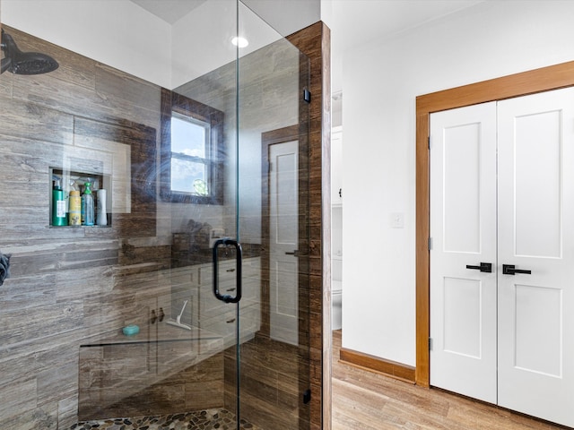 bathroom featuring wood-type flooring and an enclosed shower