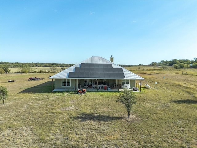 back of house with a yard and a rural view