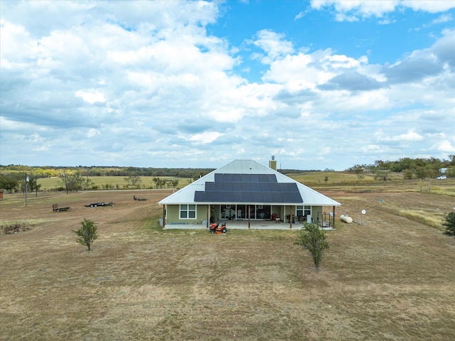 rear view of property with a rural view and solar panels