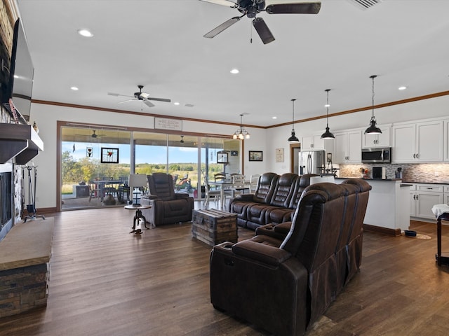 living room featuring ornamental molding, ceiling fan, a fireplace, and dark hardwood / wood-style flooring