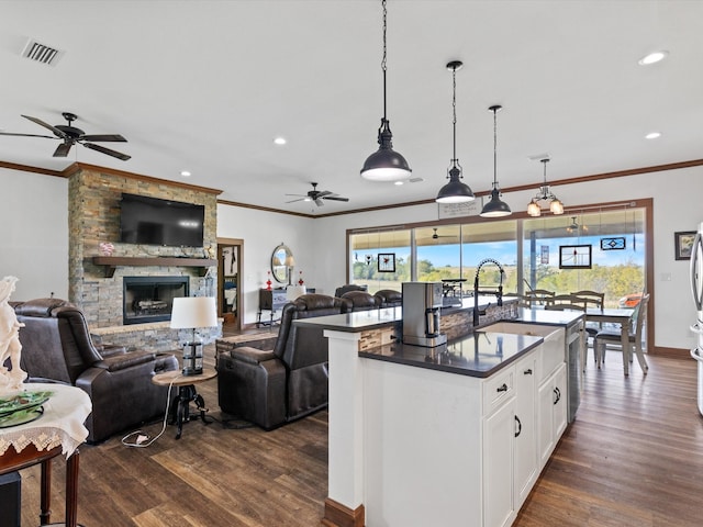 kitchen featuring dark hardwood / wood-style flooring, white cabinetry, plenty of natural light, and an island with sink