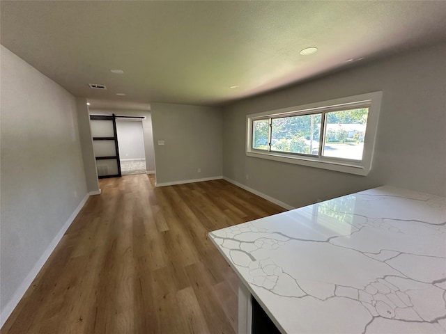 interior space with a barn door and light hardwood / wood-style flooring