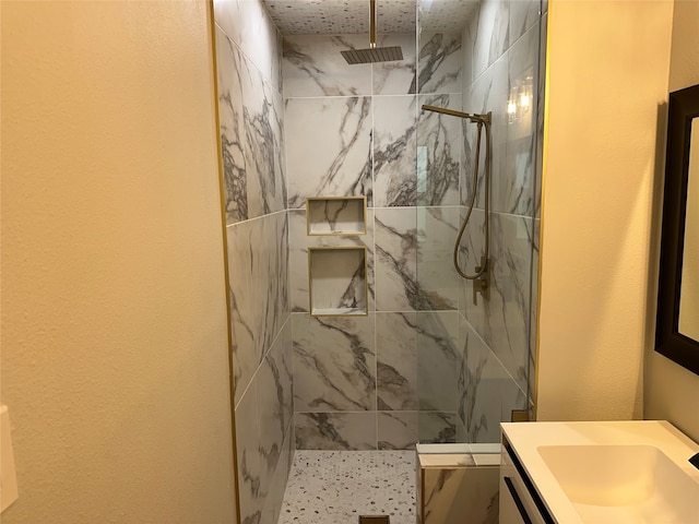 bathroom with vanity and tiled shower